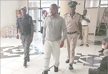  ?? (File pics) ?? Accused German Robert Dlamini being escorted by His Majesty’s Correction­al Services officers. His applicatio­n for bail is being opposed by the Crown.