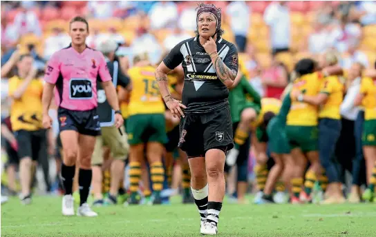 ?? PHOTOS: GETTY IMAGES ?? A disappoint­ed Laura Mariu leaves the field after the World Cup rugby league final loss to Australia in her last game for the Kiwi Ferns.