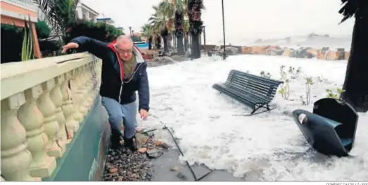  ?? DOMÉNEC CASTELLÓ / EFE ?? Un hombre intenta atravesar el paseo marítimo de Almenara (Castellón), en buena parte cubierto por el agua.