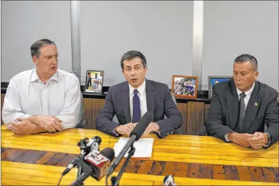  ?? Santiago Flores The Associated Press ?? South Bend Mayor Pete Buttigieg, center, speaks at a news conference Sunday in South Bend, Ind. Buttigieg changed his campaign schedule to return to South Bend after a man died in a shooting involving a police officer.