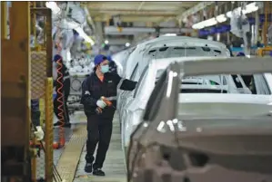  ?? ZHOU MU / XINHUA ?? An employee puts finishing touches to a Chang’an vehicle at an automobile factory in Hefei, Anhui province.