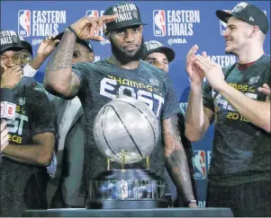  ?? AP PHOTO ?? Cleveland Cavaliers forward LeBron James salutes after his team was presented the trophy for beating the Boston Celtics 87-79 in Game 7 of the NBA Eastern Conference finals Sunday in Boston.