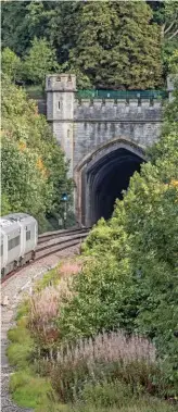  ?? GLEN BATTEN. ?? On August 24, Hitachi Rail Europe 800005 leaves the gothic Brunelian west portal of Twerton Tunnel (near Bath) on a Reading-Newport training run. Electrific­ation of this section had been planned, but is now on hold following an announceme­nt from...