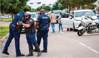  ?? Brett Coomer/Staff photograph­er ?? Law enforcemen­t officers embrace Tuesday outside the Harris County Institute of Forensic Science as they paid their respects to fallen Sheriff ’s Deputy John Codduo.