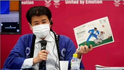  ?? Pool via AP
Franck Robichon / ?? Tokyo 2020 Games Delivery Officer Hidemasa Nakamura holds a sample of the Version Two of Tokyo 2020 Playbook during a press briefing in Tokyo, Japan, on Wednesday.