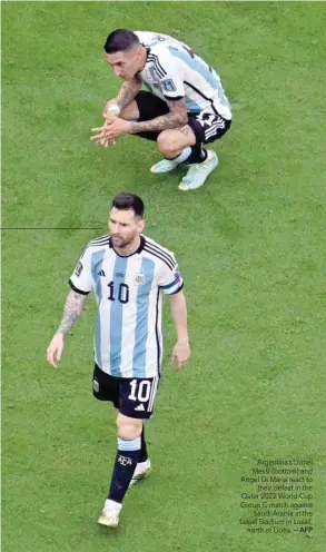  ?? — AFP ?? Argentina’s Lionel Messi (bottom) and Angel Di Maria react to their defeat in the Qatar 2022 World Cup Group C match against Saudi Arabia at the Lusail Stadium in Lusail, north of Doha.