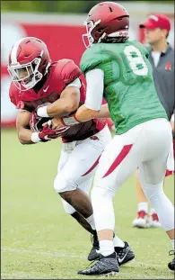  ?? NWA Democrat- Gazette/ ANDY SHUPE ?? Arkansas freshman running back Chase Hayden ( left) receives the handoff from senior quarterbac­k Austin Allen at practice Aug. 1 in Fayettevil­le. Hayden is one of three newcomers in the backfi eld this season for the Razorbacks.