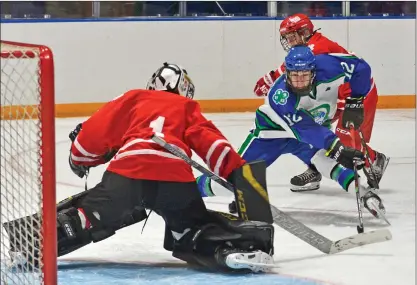  ?? STEVEN MAH/SOUTHWEST BOOSTER ?? Swift Current’s Kade Stringer (centre) had a partial breakaway chance against Notre Dame’s Mariko Bercier early in Sunday’s 13-1 win. Stringer finished the game with two goals and three assists.