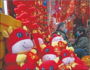  ?? Ox-themed Lunar New Year decoration­s are displayed at a store. ??