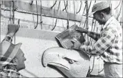  ?? David P. Shelhamer Los Angeles Times ?? WORKERS set in place the last of the 24 pieces of ceramic veneer that would make up the bald eagle on the memorial’s 68-foot pylon on its north side.