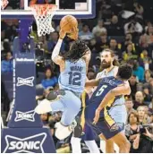  ?? BRANDON DILL AP ?? Grizzlies guard Ja Morant shoots over Pelicans forward Herbert Jones in his first game since March 18.