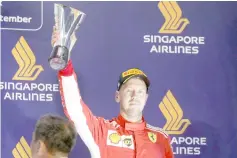  ??  ?? Ferrari’s Sebastian Vettel celebrates third place on the podium. — Reuters photo