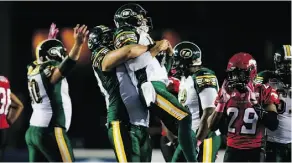  ?? JEFF MCINTOSH/THE CANADIAN PRESS ?? Matthew O’Donnell, centre, hoists Edmonton quarterbac­k Mike Reilly following the Eskimos’ 15-11 CFL win over the Stampeders in Calgary on Saturday.