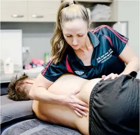  ??  ?? Albert Street Sports & Spinal Injury Centre physiother­apist Samantha Moore performing a spinal assessment.