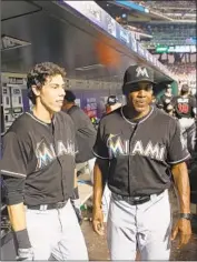  ?? Tim Clayton Getty Images ?? BARRY BONDS talks with Christian Yelich in 2016, when Bonds was the batting coach for the Miami Marlins and Yelich was one of his pupils.