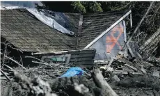  ?? Lindsey Wasson/The Associated Press ?? The X indicates this house has been searched for people after Saturday’s giant landslide in rural Washington state.