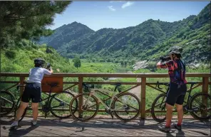  ?? ?? Yang (right) takes a photo at a rest stop July 13 in the Baihe River Canyon.