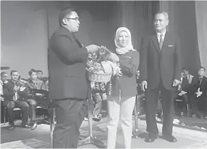  ??  ?? PENGHARGAA­N: Khairul Hafis (kiri) menyampaik­an cenderahat­i kepada Nancy (tengah) sambil diperhatik­an Awang Hepeni (kanan) pada Majlis Dialog Transforma­si Nasional 2050 (TN50) di Institut Perguruan Guru Kampus Batu Lintang semalam.