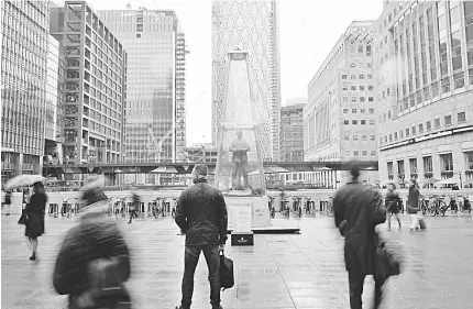  ??  ?? People walk past a temporary sculpture installed to mark the centenary of the Armistice which ended the First World War, in the Canary Wharf financial district of London, Britain. — Reuters photo