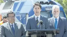  ?? PAUL CHIASSON/THE CANADIAN PRESS ?? Prime Minister Justin Trudeau announces a $1.28-billion commitment toward a major Montreal rail project flanked by Quebec Premier Philippe Couillard, right, and Montreal Mayor Denis Coderre, left, Thursday.