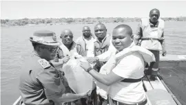  ??  ?? Zimbabwe Prisons and Correction­al Services (ZPCS) Commission­er-General Paradzai Zimondi and Matabelela­nd North Provincial Affairs Minister Cde Richard Moyo (centre) are joined by ZPCS Officer Commanding Matabelela­nd North Province Senior Assistant Commission­er Moddie Nkomo and Chief Mabhikwa in carrying fingerling­s to commission the ZPCS aquacultur­e fish cages at Bubi-Lupane Dam in Lupane yesterday. — (Picture by Eliah Saushoma)