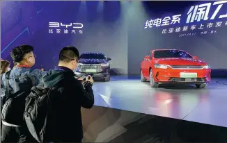  ?? ZHANG DANDAN / CHINA DAILY ?? BYD launches its new electric models, including the 2021 Tang EV and the Qin Plus EV, last week in Chongqing. The new SUV and sedan are equipped with the automaker’s self-developed blade-shaped batteries.