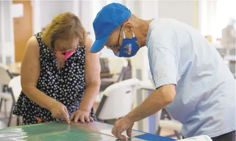  ?? GABRIELLE RHOADS/THE MORNING CALL ?? Retired nurse Ruth Dennison and Mark Theoret cut vinyl together to put into mask-making kits.