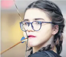  ?? ERIC WYNNE/CHRONICLE HERALD ?? Gabrielle Goodland bites down on her mouth release as she practices archery in the gym of Ecole Secondaire du Sommet. The 15-year-old archer has limited use of her right arm and is partially blind in her left eye. The challenges hasn’t stopped the plucky teenager as she gets ready for the 2024 Paralympic­s.