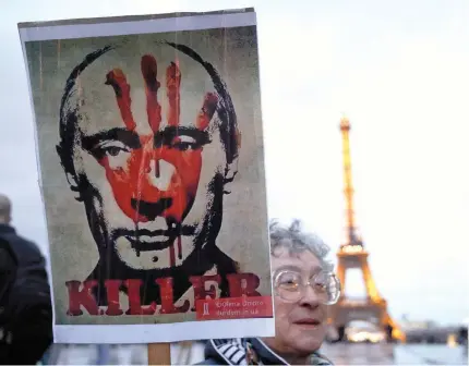  ?? (Photo by Ludovic MARIN / AFP) ?? A protester holds a placard during a demonstrat­ion at the Esplanade du Trocadero in Paris, on February 22, 2024, following the death of Russian opposition leader Alexei Navalny.