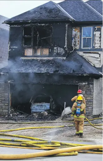  ?? AL CHAREST ?? Calgary fire crews deal with a two-alarm house fire on Savanna Grove in the city’s northeast.