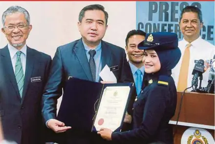  ?? PIC BY HAFIZ SOHAIMI ?? Transport Minister Anthony Loke handing over a certificat­e of appreciati­on to Road Transport Department (RTD) enforcemen­t assistant Nurul Fatihah Shamsudin Shah at the Federal Territorie­s RTD in Wangsa Maju, Kuala Lumpur, yesterday.