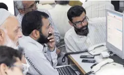  ??  ?? KARACHI: Pakistani stockbroke­rs watch share prices on a computer monitor during a trading session at the Karachi Stock Exchange (KSE) in Karachi yesterday. The benchmark KSE-100 index ended at 26097.49, down 584.29 points midway through the day’s...