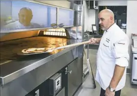  ?? Nate Guidry/Post-Gazette ?? Jason Whitecotto­n, executive chef at Heinz Field, prepares a Gina Margherita pizza Wednesday at the stadium on the North Shore.