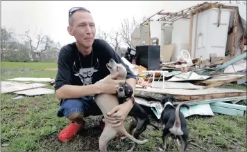  ?? PICTURE: AP ?? Sam Speights tries to hold back tears yesterday while holding his dogs and surveying the damage to his home in Rockport, Texas. Speights had to move to a shelter after his house lost its roof and back wall.