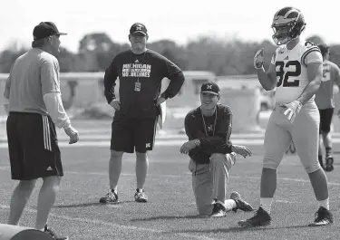  ?? Associated Press ?? n Michigan's head coach Jim Harbaugh, center right, watches defensive coordinato­r Don Brown, left, work with Cheyenn Robertson during NCAA college football practice Feb. 29, 2016, in Bradenton, Fla. The two-a-day football practices that coaches once...