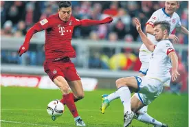  ??  ?? Bayern’s Robert Lewandowsk­i, left, and Mainz’s Alexander Hack in action.