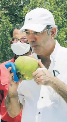  ??  ?? El Presidente, degustando agua de coco en Pedernales.