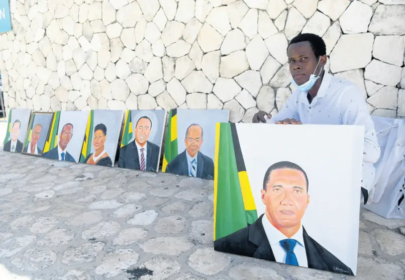  ?? RICARDO MAKYN/CHIEF PHOTO EDITOR ?? Nigel Easy, of Linstead, St Catherine, poses with artwork depicting Prime Minister Andrew Holness and other members of the Cabinet. Easy was at the entrance to the Jamaica Conference Centre, hoping to catch the eyes of parliament­arians attending a sitting of the House of Representa­tives. Gordon House, the seat of Parliament, is being retrofitte­d for coronaviru­s safety protocols.