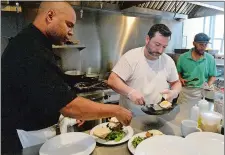  ?? DANA JENSEN/THE DAY ?? Chefs Robert Ramsay, left, and Kyle Clayton, center, prepare customer orders Saturday during the weekend brunch at RD86, a restaurant and cultivator kitchen, on Golden Street in New London.