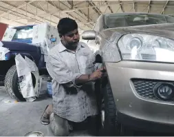  ?? Chris Whiteoak / The National ?? Mohammed Abbid works on a dent at Tiptop, a garage in Al Quoz, Dubai