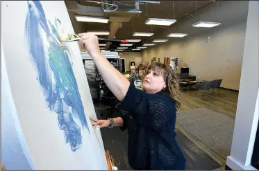  ?? NWA Democrat-Gazette/J.T. WAMPLER ?? Artist Shawna Elliott paints Thursday at 1 Seventeen Create in Springdale. The space features artists’ work space as well as gallery and exhibition space. The Walton Family Foundation has partnered with national nonprofit group Artspace on a $400,000...