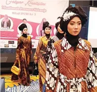  ?? FIRMA ZUHDI/JAWA POS ?? UNJUK KARYA: Model-model muslimah memperagak­an busana batik karya para muslimah pengusaha kemarin.