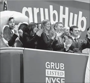  ?? Richard Drew Associated Press ?? GRUBHUB, one of the few “gig economy” firms to have already gone public, declined to comment on whether it compensate­d its delivery personnel with stock. Above, GrubHub’s debut on the New York Stock Exchange.