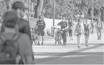  ?? Ralph Barrera / Austin American-Statesman via Associated Press ?? University of Texas Police patrol the Austin campus on Tuesday, the day after a student was fatally stabbed. Police stepped up patrols and officials urged students to walk in pairs and stay in well-lit areas.