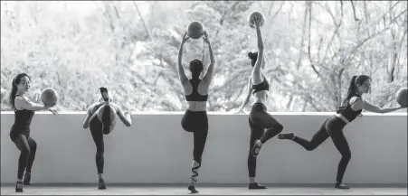  ??  ?? Coaches at Supermonke­y prepare for a barre class, which uses movements from ballet, as well as yoga and pilates positions.