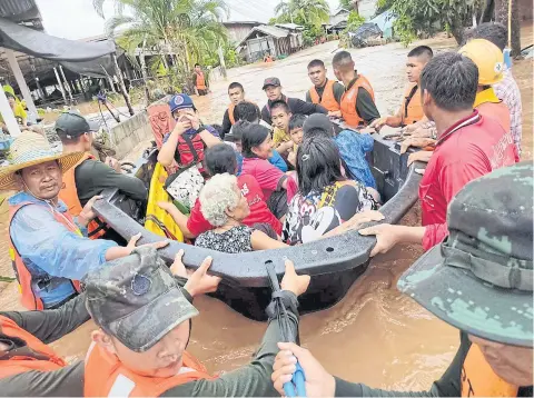  ?? THE ROYAL THAI ARMY ?? Soldiers evacuate villagers in Muang district of Loei province after run-off water caused by heavy rain engulfed over 1,000 houses in districts including Muang, Chiang Khan, Pak Chom and Na Duang. Hardest hit is Muang district where over 400 houses were flooded, up to 70 centimetre­s in some areas.