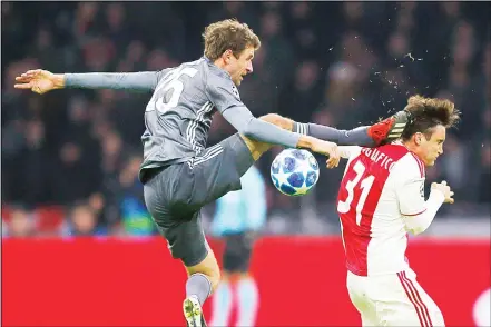  ??  ?? Ajax’s Nicolas Tagliafico (right), is fouled by Bayern’s Thomas Mueller during the Champions League Group E soccer match between Ajax and FC BayernMuni­ch at the Johan Cruyff Arena in Amsterdam, Netherland­s on Dec 12. (AP)
