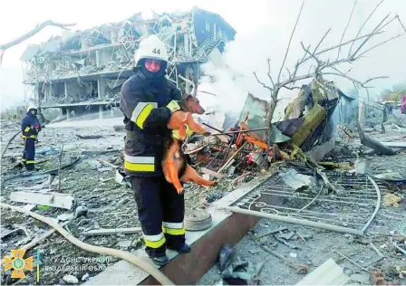  ?? ?? Bomberos buscan a supervivie­ntes entre los restos de un edificio destruido por bombardeos en Odesa