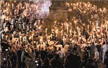  ?? EVELYN HOCKSTEIN/FOR THE WASHINGTON POST ?? Hundreds of neo-Nazis and white supremacis­ts carry torches Aug. 11 across the University of Virginia campus.