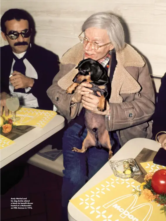  ?? ?? Andy Warhol and his dog Archie attend a black-tie benefit dinner hosted at a Mcdonald’s on Fifth Avenue in 1976.